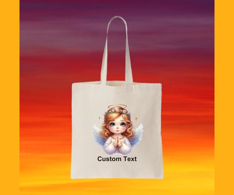 May include: White tote bag with a design of a cartoon angel with blonde hair and a halo. The angel is wearing a white dress and has her hands clasped in prayer. The text "Custom Text" is printed below the angel.