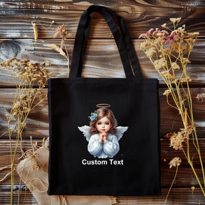 Pode incluir: Sacola de tecido preta com uma ilustra&ccedil;&atilde;o de um anjo branco e o texto "Custom Text".