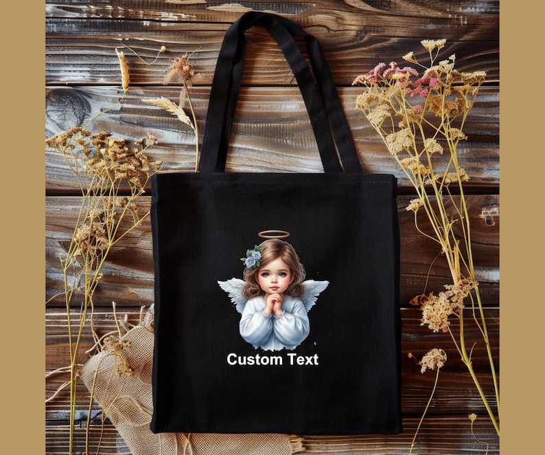 Pode incluir: Sacola de tecido preta com uma ilustra&ccedil;&atilde;o de um anjo branco e o texto "Custom Text".
