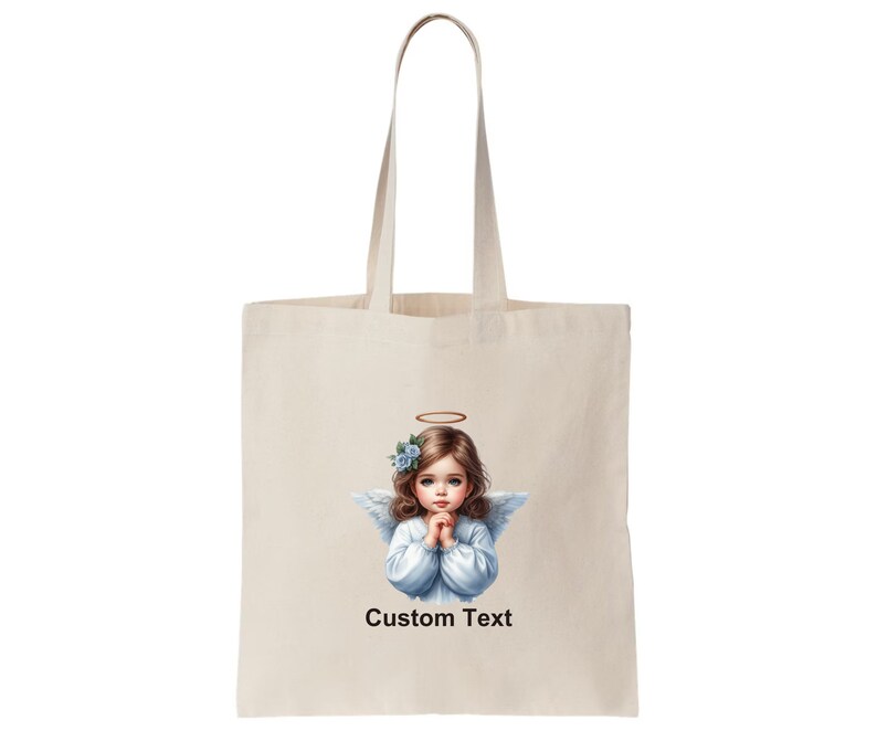 Pode incluir: Uma bolsa tote branca com uma imagem impressa de um anjo com flores azuis no cabelo. O anjo est&aacute; vestindo um vestido branco e tem uma aur&eacute;ola acima de sua cabe&ccedil;a. O texto "Custom Text" est&aacute; impresso abaixo da imagem.