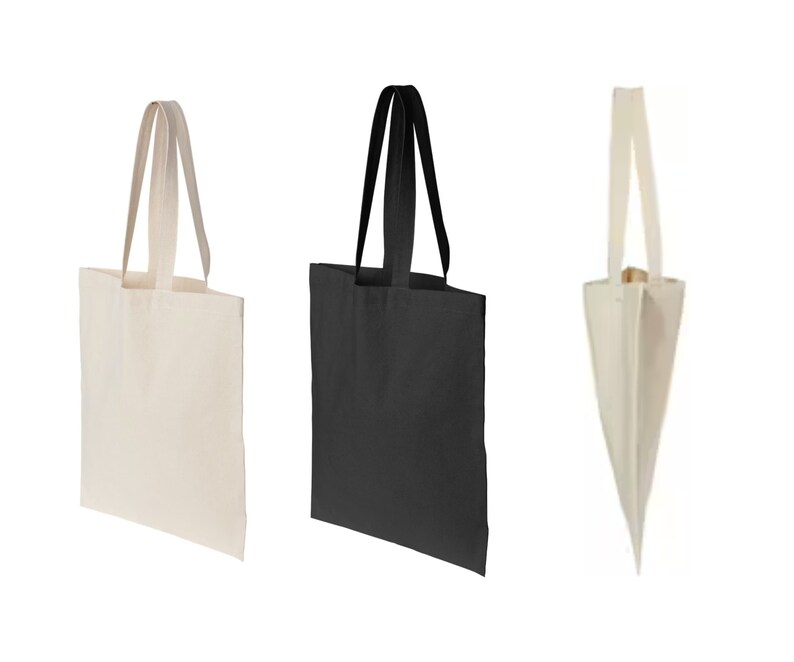 May include: Three tote bags, one white, one black, and one natural canvas. The bags have a simple design with two handles.