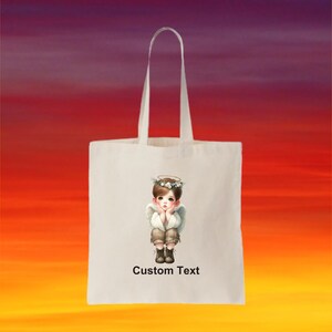 May include: White tote bag with a design of a young angel with a halo and wings. The text "Custom Text" is printed on the bag.