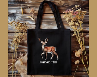 May include: Black canvas tote bag with a brown and white deer illustration and the text "Custom Text".