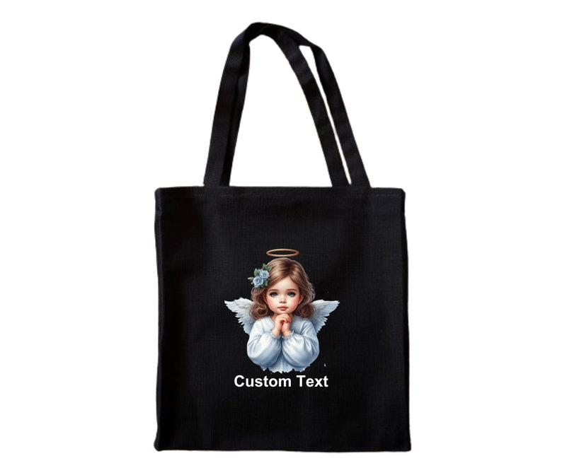 Pode incluir: Sacola de tecido preta com um anjo branco com halo e flores azuis no cabelo. O anjo est&aacute; com as m&atilde;os juntas em ora&ccedil;&atilde;o. O texto "Custom Text" est&aacute; impresso abaixo do anjo.