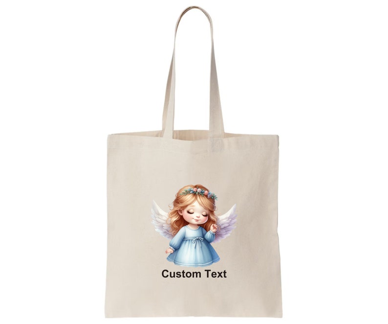 Puede incluir: Una bolsa de tela beige con una ilustraci&oacute;n blanca de un &aacute;ngel con cabello rubio, ojos azules y un vestido azul claro. El &aacute;ngel lleva una corona de flores. El texto "Custom Text" est&aacute; impreso en la bolsa.
