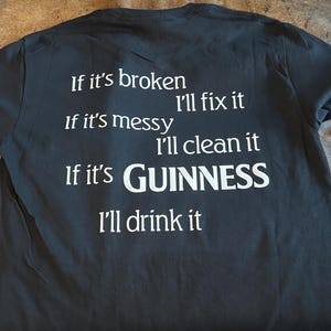 May include: Black t-shirt with white text. The text reads: "If it's broken, I'll fix it. If it's messy, I'll clean it. If it's GUINNESS, I'll drink it."
