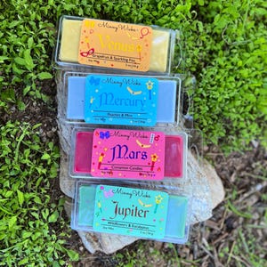 Peut inclure: Quatre barres de cire de soja parfumée dans des boîtes en plastique transparent. Les barres sont jaunes, bleu clair, roses et vertes. Chaque barre a une étiquette avec un nom de planète et un parfum: Vénus, Mercure, Mars et Jupiter. Chaque barre est de 56g.
