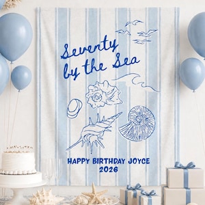 May include: A birthday party scene with a blue and white striped backdrop that reads "Seventy by the Sea." The scene includes blue balloons, a cake, gifts, and seashells. The text "Happy Birthday Joyce 2026" is also visible.