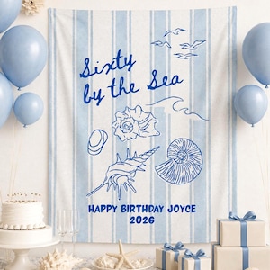 Może przedstawiać: Scena przyjęcia urodzinowego z niebieskimi balonami, tortem i prezentami. W tle wisi baner z napisem "Sixty by the Sea" i ilustracjami muszli. Widoczny jest również napis "Happy Birthday Joyce 2026".
