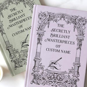 May include: Two hardcover books with the text "The Secretly Brilliant Masterpieces of Custom Name" in black script. One book is sage green, the other is lavender. Both books feature an ornate black illustration of an archway and a quill pen.