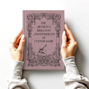 Journal shown in the color "raisin" by a model's hands on a smooth light gray surface.