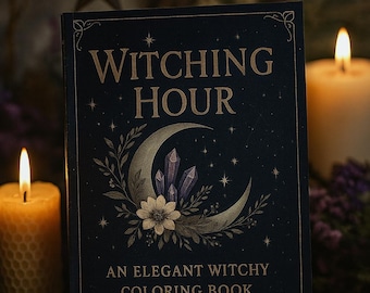 May include: A dark blue coloring book titled "Witching Hour" with gold lettering and illustrations of a crescent moon, crystals, and flowers. The book is open on a stack of books, with lit candles and a star-shaped ornament in the background.