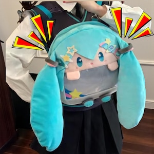 May include: A light blue plush backpack featuring a cartoon character design with long, light blue pigtails. The backpack has a star and planet design, with a light pink face and blue eyes. The bag has a shoulder strap and a zipper closure.