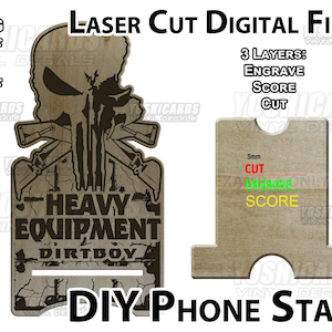 May include: Laser cut digital files for a DIY phone stand. The design features a skull with crossed rifles, the text "HEAVY EQUIPMENT DIRTBOY", and instructions for engraving, scoring, and cutting. Includes SVG, DXF, AI, and PDF files.
