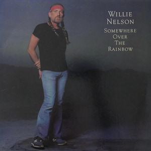 Könnte beinhalten: Albumcover mit Willie Nelson, der ein schwarzes T-Shirt, eine blaue Jeans und ein rotes Bandana trägt. Der Albumtitel "Somewhere Over The Rainbow" ist in weißem Text auf dunklem Hintergrund dargestellt. Das Bild zeigt ein Porträt des Musikers.