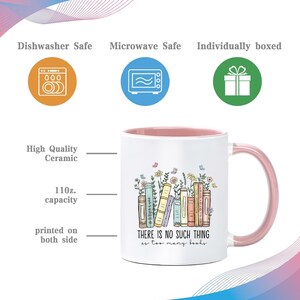May include: White ceramic mug with a pink interior and handle, featuring a colorful illustration of books and flowers. The mug has a capacity of 11 oz and the text "THERE IS NO SUCH THING as too many books."