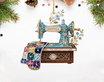 May include: A decorative ornament featuring a vintage sewing machine in teal and gold, with the name "SHOPHIA" on the front. The machine has a colorful quilt draped over the base, and is adorned with floral accents. A perfect gift for a seamstress.