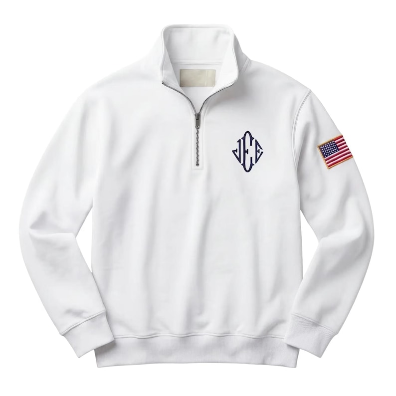May include: White quarter-zip sweatshirt with a navy blue monogram and an American flag patch on the sleeve. The sweatshirt has a stand-up collar and a silver zipper. The monogram is in a diamond shape.