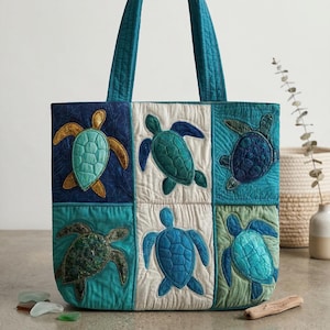 Puede incluir: Un bolso tote acolchado con asa turquesa y un diseño de patchwork con tortugas marinas. Las tortugas son en tonos turquesa, azul y dorado, sobre un fondo de cuadrados blancos y azules. El bolso es de tela.