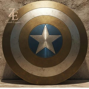 May include: A round shield with a metallic finish, featuring concentric circles in gold, silver, and blue. A silver star is centered on a blue circle. The shield has a weathered appearance, suggesting a vintage or battle-worn aesthetic. The text "Zarah Exports" is visible.