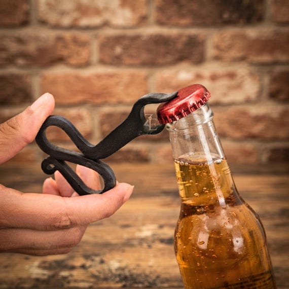 A blacksmith actually hammered this medieval-style squeeze bottle opener from raw metal — it looks like it was pulled from a tavern wall in 1347.