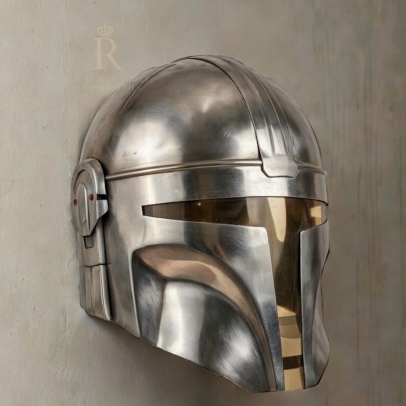 Puede incluir: Un casco met&aacute;lico plateado con visera y orejeras. El casco tiene una superficie lisa y reflectante y un dise&ntilde;o que recuerda a una armadura de ciencia ficci&oacute;n o fantas&iacute;a. La visera es de color dorado contrastante.
