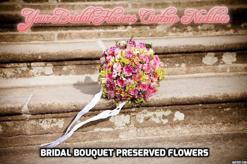 Puede incluir: Un ramo de novia de flores preservadas en tonos rosas y verdes, con una cinta blanca, sobre un conjunto de escalones de piedra. El texto "Your Bridal Flowers Custom Necklace" se muestra sobre el ramo.
