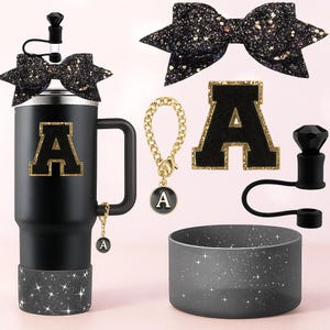 Pode incluir: Caneca preta com a letra "A" com acabamento dourado e laço a condizer. Inclui um berloque de corrente dourada com um pendente "A", uma tampa preta e uma base brilhante. Acessórios: patch "A" preto e manga de copo cinza.
