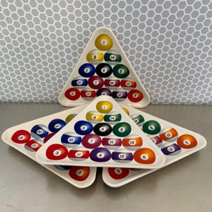 May include: White triangular serving platters with a billiard ball design. Each platter features a set of numbered billiard balls in a triangular arrangement. The balls are in various colours, including yellow, blue, red, and green.