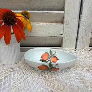 Small oval dish in Limoges porcelain from Maison de la Porcelaine, decorated with oranges and flowers, ideal as a pocket emptier or jewelry holder.
