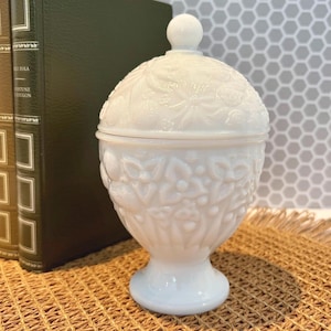 White opaline glass jar with floral relief and Avon Charisma candle, reusable candy dish in a romantic Victorian style