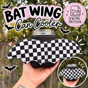 May include: A black fabric can cooler featuring white and black checkered bat wings attached to the sides. The text BAT WING Can Cooler and SEWING PATTERN is displayed above the item, which is wrapped around a clear glass jar.