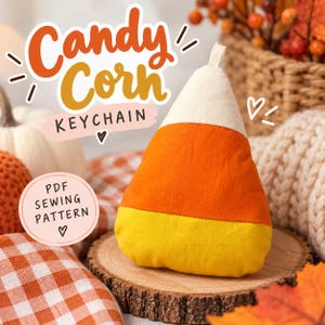 Könnte beinhalten: Ein Stoff-Schlüsselanhänger in Form eines Candy Corn mit horizontalen Streifen in Weiß, Orange und Gelb. Das Bild enthält den Text Candy Corn KEYCHAIN und PDF SEWING PATTERN sowie dekorative Herz- und Strichsymbole.