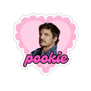 May include: A sticker with a portrait of a man in a denim jacket, framed by a pink heart with a scalloped edge. The word "pookie" is written in pink cursive font below the portrait.