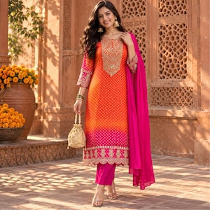 May include: A vibrant orange and pink ombre tunic featuring a white polka dot pattern, intricate gold embroidery around the neckline and hem, paired with solid pink trousers and a matching pink dupatta, accessorised with a gold beaded drawstring bag.