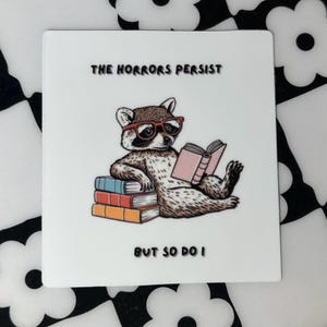 The Horrors Persist But So Do I Vinyl Sticker | Funny Book Raccoon Vinyl Decal