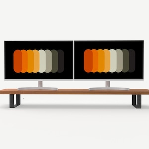 Könnte beinhalten: Ein langer Monitorständer aus Holz mit zwei schwarzen, U-förmigen Metallbeinen, auf dem zwei Computerbildschirme stehen. Jeder Bildschirm zeigt eine horizontale Reihe abgerundeter vertikaler Balken in einem Farbverlauf aus Orange, Gelb, Beige, Grau und Dunkelgrün.