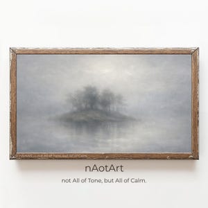 Pode incluir: Uma impressão emoldurada de uma paisagem nebulosa com uma ilha arborizada e seu reflexo na água. A obra de arte tem uma paleta de cores suaves de cinzas e marrons, com o texto "nAotArt not All of Tone, but All of Calm."