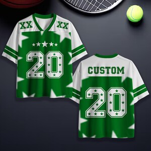 Puede incluir: Una camiseta deportiva verde y blanca con el n&uacute;mero 20 y detalles de estrellas. La camiseta tiene cuello en V y mangas a rayas. La palabra "CUSTOM" est&aacute; en la espalda.
