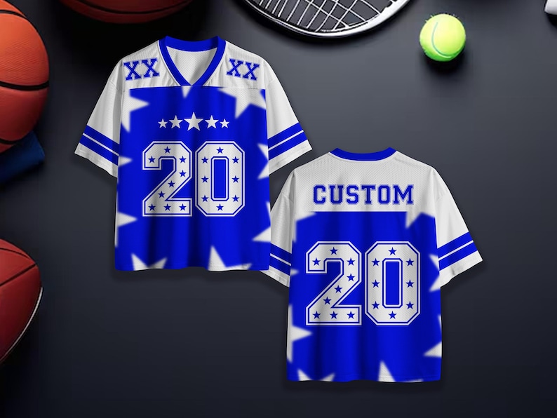 Puede incluir: Una camiseta deportiva azul y blanca con el n&uacute;mero 20 y detalles de estrellas. La camiseta tiene cuello en V y la palabra "CUSTOM" en la espalda. Se muestra con equipamiento deportivo de fondo.