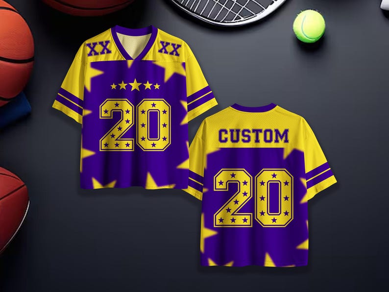 Puede incluir: Una camiseta deportiva morada y amarilla con el n&uacute;mero 20 en negrita. La camiseta tiene cuello en V y detalles de estrellas. La palabra "CUSTOM" est&aacute; impresa en la espalda.