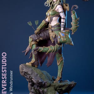 Op de afbeelding: Een gedetailleerd beeldje van Alleria Windrunner op een rotsachtige basis. Het personage draagt een groen en bruin harnas met gouden accenten, een kap, en draagt een boog en pijlen. De tekst op de zijkant luidt KYLEVERSESTUDIO Alleria Windrunner.