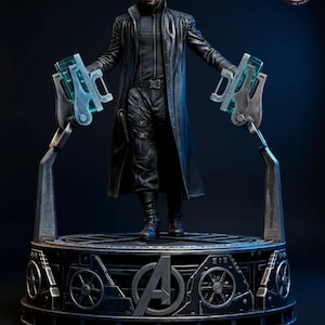 Peut inclure: Figurine détaillée d'un personnage en long manteau noir, debout sur une plateforme circulaire. La figurine a un cache-œil et tient deux armes futuristes avec des accents bleus. La plateforme présente le logo des Avengers et des détails mécaniques.