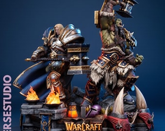 May include: A detailed Warcraft Reign of Chaos diorama featuring a blonde human warrior in silver armor holding a hammer and a green-skinned orc warrior in fur-trimmed armor raising a large hammer, set on a base with flames and text.