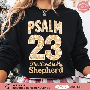 Pode incluir: Camisola preta com o texto "PSALM 23 The Lord Is My Shepherd" em bege e branco. O número 23 é decorado com flores margaridas. As palavras "High Quality Digital Download" também são visíveis.