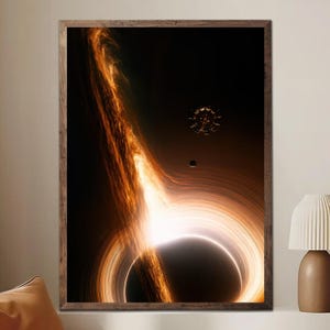 May include: A framed art print depicting a black hole with swirling orange and white energy. A bright white light emanates from the center, surrounded by a dark void. A small, dark sphere and a circular object are also visible.