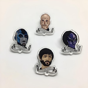 Puede incluir: Cuatro pines de acrílico transparente con personajes de dibujos animados y texto. El primer pin presenta un personaje de piel azul con el texto "BORE BITCH". El segundo pin presenta un personaje calvo con el texto "I'M NOT AFRAID OF  YOU". El tercer pin presenta un personaje de piel morada con el texto "KILL ME NOW". El cuarto pin presenta un personaje barbudo con el texto "I LIKE SCIENCE".