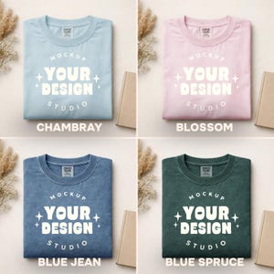 Peut inclure: Quatre t-shirts pli&eacute;s de couleurs chambray, blossom, blue jean et blue spruce. Chaque chemise porte un graphisme blanc avec l'inscription "MOCKUP YOUR DESIGN STUDIO". Les chemises sont pr&eacute;sent&eacute;es sur un fond neutre avec un livre et des fleurs s&eacute;ch&eacute;es.