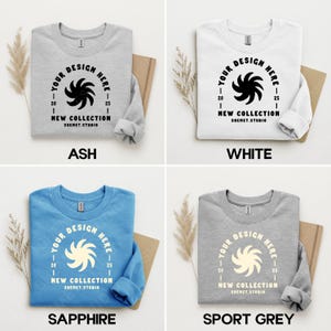 Puede incluir: Cuatro sudaderas de cuello redondo en ceniza, blanco, zafiro y gris deportivo. Cada sudadera presenta un dise&ntilde;o circular con el texto "YOUR DESIGN HERE" y "NEW COLLECTION SHEMET.STUDIO". Las sudaderas se muestran sobre un fondo neutro.