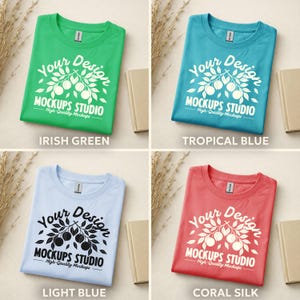 May include: Four folded t-shirts in different colors: Irish Green, Tropical Blue, Light Blue, and Coral Silk. Each shirt has a white graphic design with the text "Your Design MOCKUPS STUDIO High-Quality Mockups".